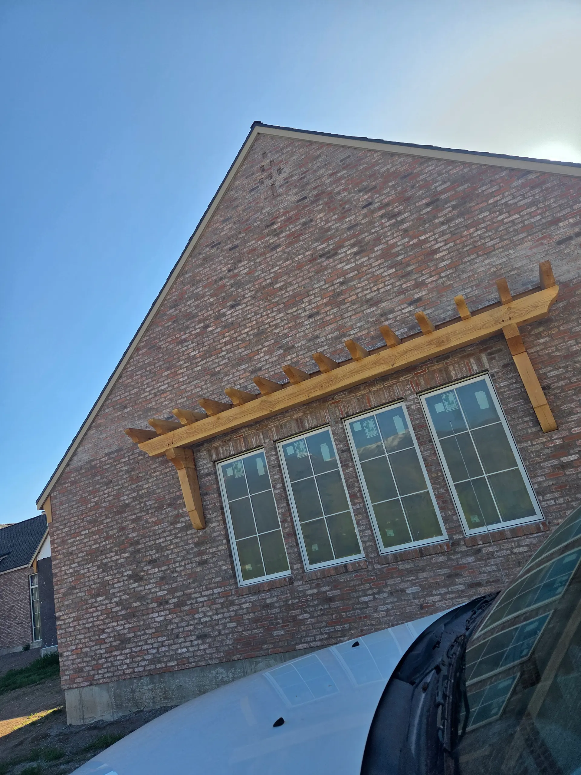Brick gable wall with cedar pergola accent by Spackman Construction Services
